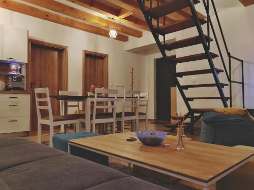 uma sala de estar com uma mesa de madeira e uma escada em espiral em Holiday home D&D em Bosanska Krupa