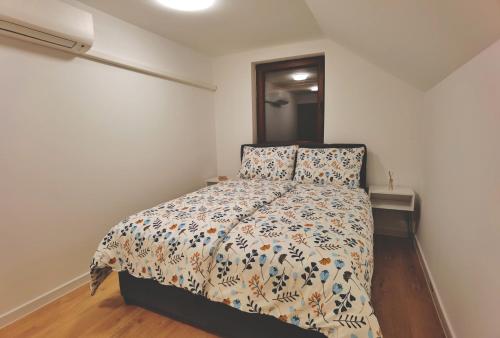 um quarto com uma cama com um edredão e almofadas em Holiday home D&D em Bosanska Krupa
