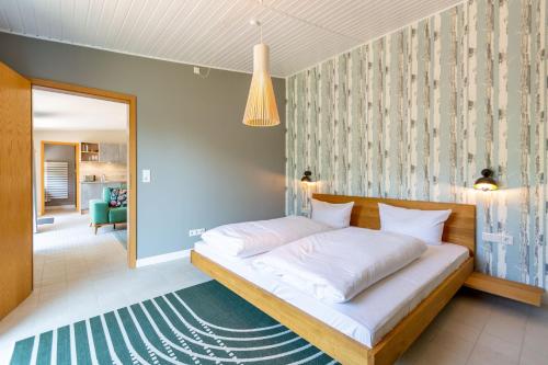een slaapkamer met een groot bed met witte lakens bij Haus Silvana in Zempin