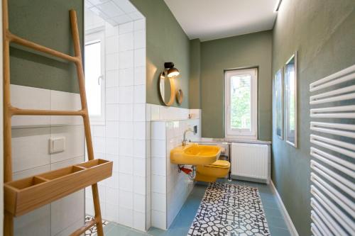 baño con aseo amarillo y lavamanos amarillo en Haus Silvana, en Zempin
