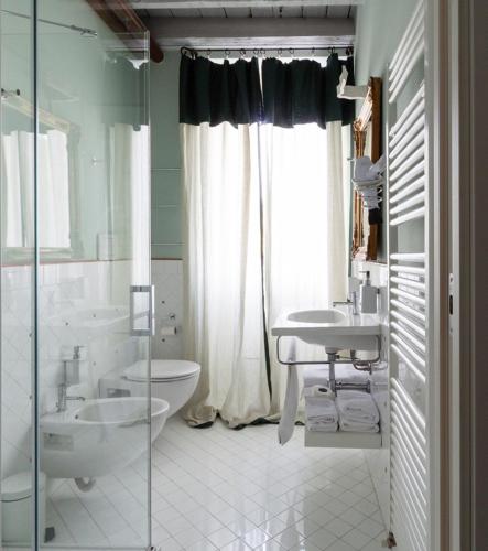 a bathroom with two sinks and a toilet and a shower at B&B a Ca' Minore Franciacorta in Passirano