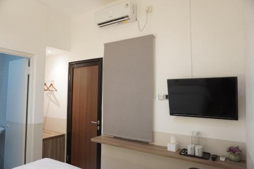 a room with a flat screen tv on a wall at Aurora House Surabaya in Wijung