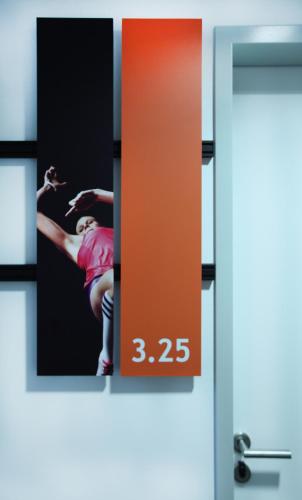 a clock on a door with a picture of a woman at Lindner Hotel Frankfurt Sportpark, part of JdV by Hyatt in Frankfurt/Main