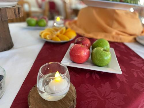 a table with a candle and apples and plates of fruit at Hotel Select in Piriápolis