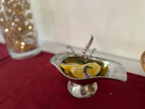 a metal dish with lemon slices in it on a table at Hotel Select in Piriápolis