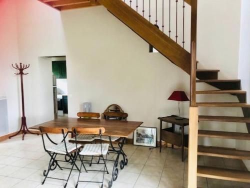 une salle à manger avec une table et un escalier dans l'établissement L'écurie, à Varengeville-sur-Mer