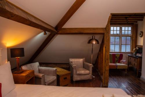 a room with a bed and two chairs and a window at Haweswater Hotel in Bampton