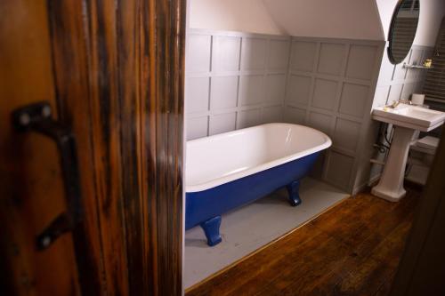 a bath tub in a bathroom with a sink at Haweswater Hotel in Bampton