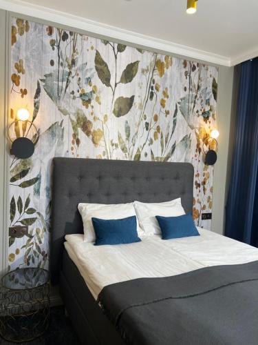 1 dormitorio con 1 cama y papel pintado con motivos florales en Sadama street Villa, en Pärnu