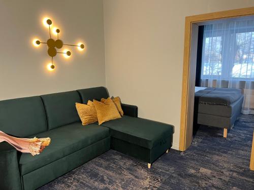 a living room with a green couch and a window at Sadama street Villa in Pärnu