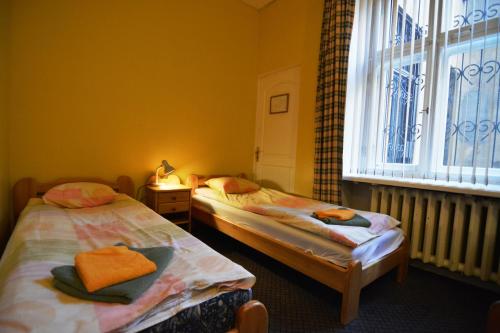 two twin beds in a room with a window at Hotel Multilux with Self Check-in in Riga