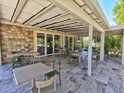 a patio with tables and chairs and a stone wall at Agriturismo e Acetaia la Vedetta in Castelvetro di Modena