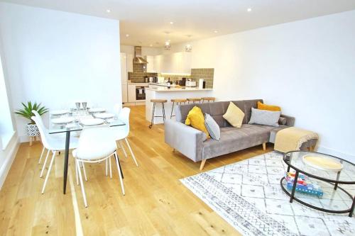 a living room with a couch and a table at Modern Apartment for Contractors & Small Groups by Stones Throw Apartments - Free Parking - Sea View in Worthing