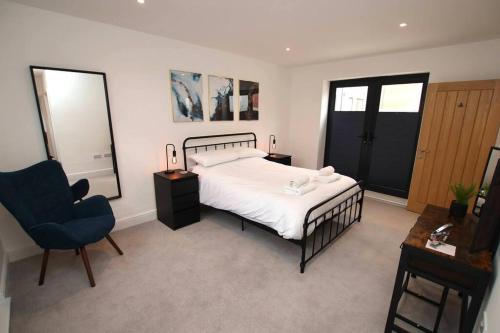 una camera con letto e sedia blu di Modern Apartment for Contractors & Small Groups by Stones Throw Apartments - Free Parking - Sea View a Worthing