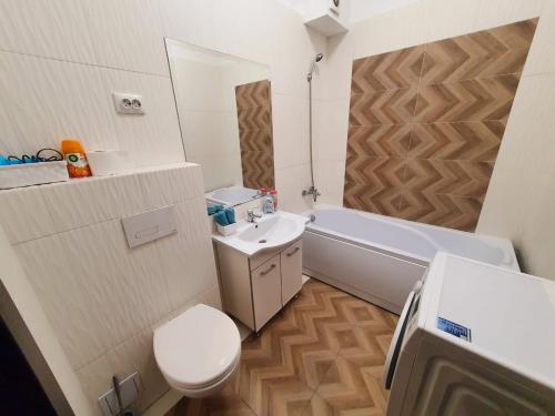 La salle de bains est pourvue d'un lavabo, de toilettes et d'une baignoire. dans l'établissement Concept Residence Regim Hotelier, à Iaşi