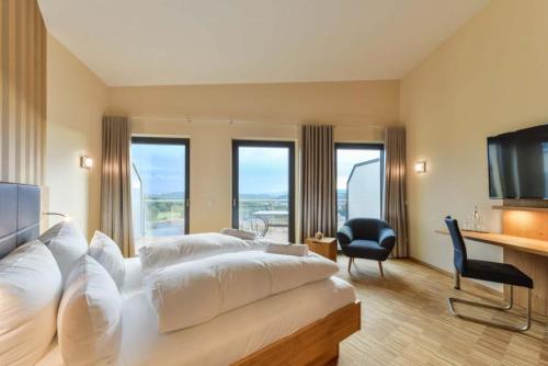 a bedroom with a large white bed and a desk at Hotel & Golfrestaurant Gut Wissmannshof in Staufenberg