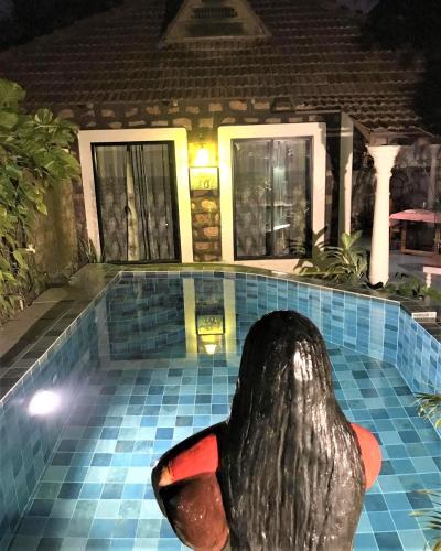 a statue of a whale in a pool at night at Marari Dreamz Homestay in Mararikulam