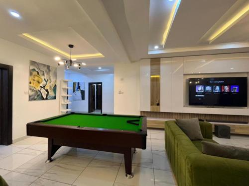a living room with a pool table and a couch at Lovely 3-Bed with a Pool next to Four Point in Lagos