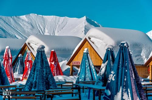 a group of tables and chairs in front of snow covered buildings at New Gudauri 312 in Gudauri