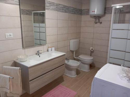 een badkamer met een wastafel, een toilet en een spiegel bij Ca' di Burghi 2 in Busca