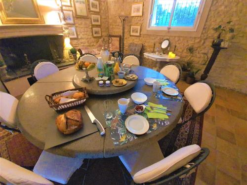 een tafel met eten in de woonkamer bij Le Manoir Lacustre in Queyrac