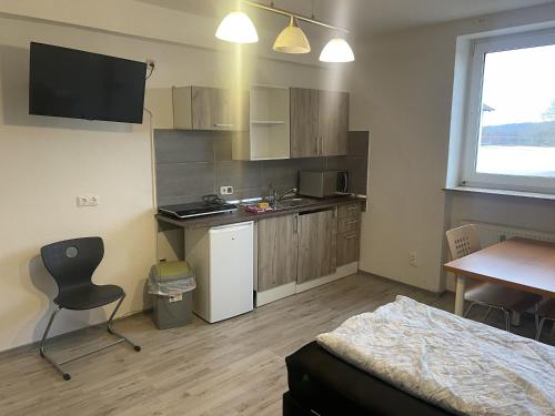 a small kitchen with a desk and a table with a chair at Bed4You Gästehaus 2 in Kassel