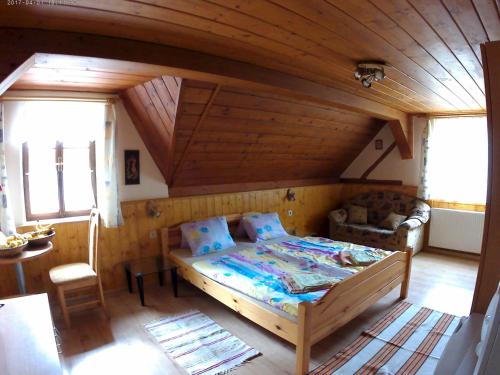 1 dormitorio con 1 cama en una habitación de madera en Ubytování U Potoka, en Kunratice