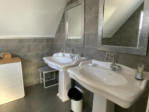 a bathroom with two sinks and a mirror at Superbe Villa Face à L'Océan in Plouhinec