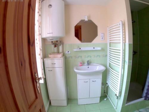 La petite salle de bains est pourvue d'un lavabo et d'un miroir. dans l'établissement Ubytování U Potoka, à Kunratice