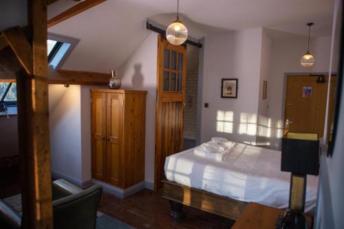 a bedroom with a bed and a table and a chair at Haweswater Hotel in Bampton