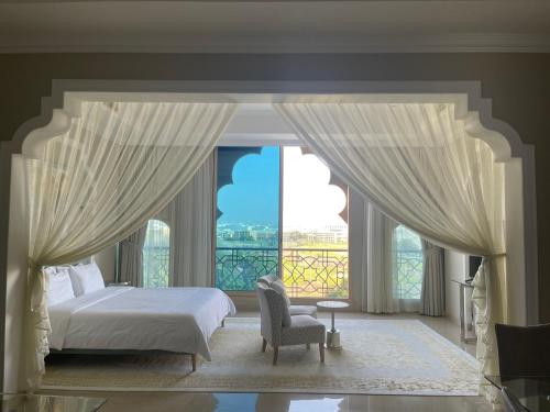 a bedroom with a bed and a large window at Private Suites Al Hamra Palace at golf & sea resort in Ras al Khaimah