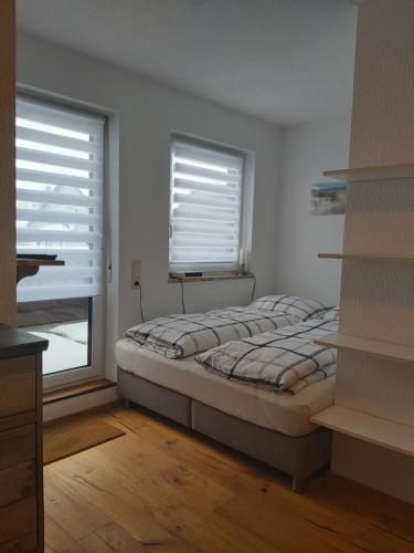 - une chambre avec un lit et une fenêtre avec des stores dans l'établissement Ferienwohnung Munzert, à Zell im Fichtelgebirge