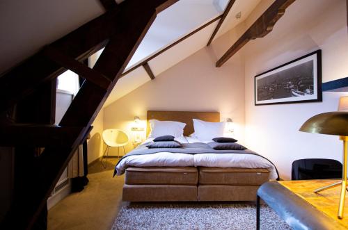 a bedroom with a bed in a attic at Suitehotel Pincoffs in Rotterdam
