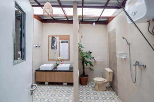 a bathroom with two sinks and a shower and a toilet at Rumah Container Bedugul in Bedugul