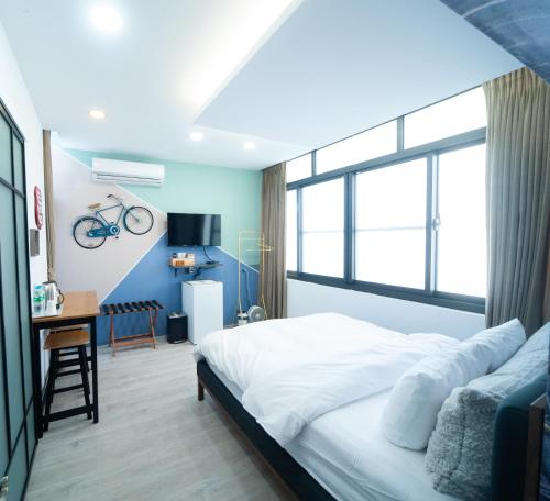 會呼吸的房507-睡虎尾-電梯bnb في Huwei: غرفة نوم مع سرير ودراجة على الحائط
