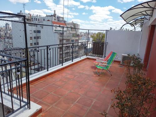 balkon z zielonym krzesłem na dachu budynku w obiekcie Hermoso Departamento en Recoleta muy luminoso w BuenosAires