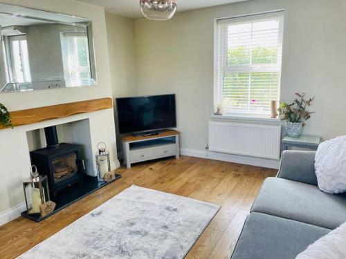 a living room with a couch and a fireplace at Entire 2 bed cottage - Llangwm in Llangwm
