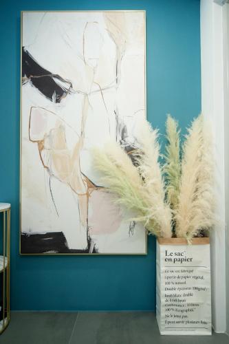 a painting on a blue wall with feathers in a vase at 會呼吸的房-採自助式入住-有電梯 in Huwei