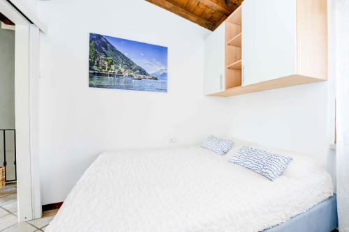 1 dormitorio con 1 cama en una habitación blanca en Gardaliva - Home & Garden by Garda FeWo, en Manerba del Garda