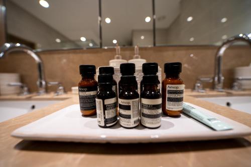 four bottles of honey sitting on a cutting board in a bathroom at Majestay - Luxury Living in Dubai