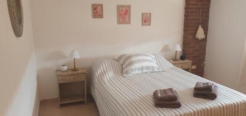 ein Schlafzimmer mit einem Bett mit zwei braunen Handtüchern darauf in der Unterkunft Departamentos Don Guillo in Alta Gracia