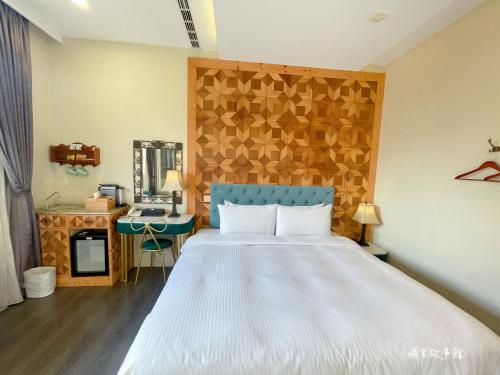 a bedroom with a large bed with a blue headboard at Puli Story House in Puli