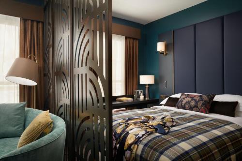 a bedroom with a bed and a couch and a table at The Other House South Kensington in London