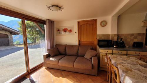 a living room with a couch and a table at Chalet Coquelicot confort cosy au coeur du village de Saint Martin in Saint-Martin-de-Belleville