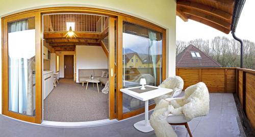 a patio with two chairs and a table on a balcony at AHA Jasná Apartmány in Liptovský Mikuláš