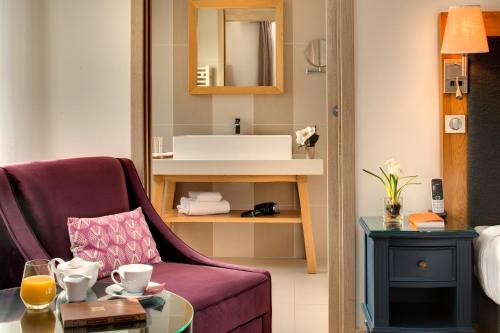 een woonkamer met een paarse stoel en een tafel bij Hotel Castel Maintenon - Handwritten Collection in Maintenon
