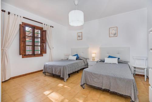 a room with two beds and a window at Can Canaves in Pollença