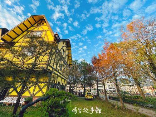 a yellow building with trees and a yellow at Puli Story House in Puli