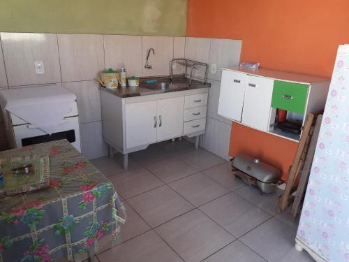 una pequeña cocina con fregadero y mesa en Casa Pôr do Sol, en São Thomé das Letras