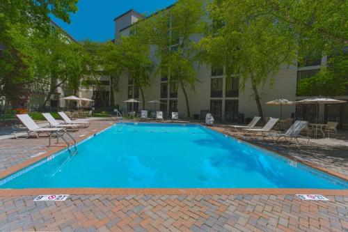 a large blue swimming pool with chairs and umbrellas at Wyndham Executive Center Columbia in Columbia